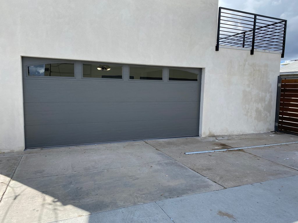 Gray modern flush garage door with arched windows, North Park
